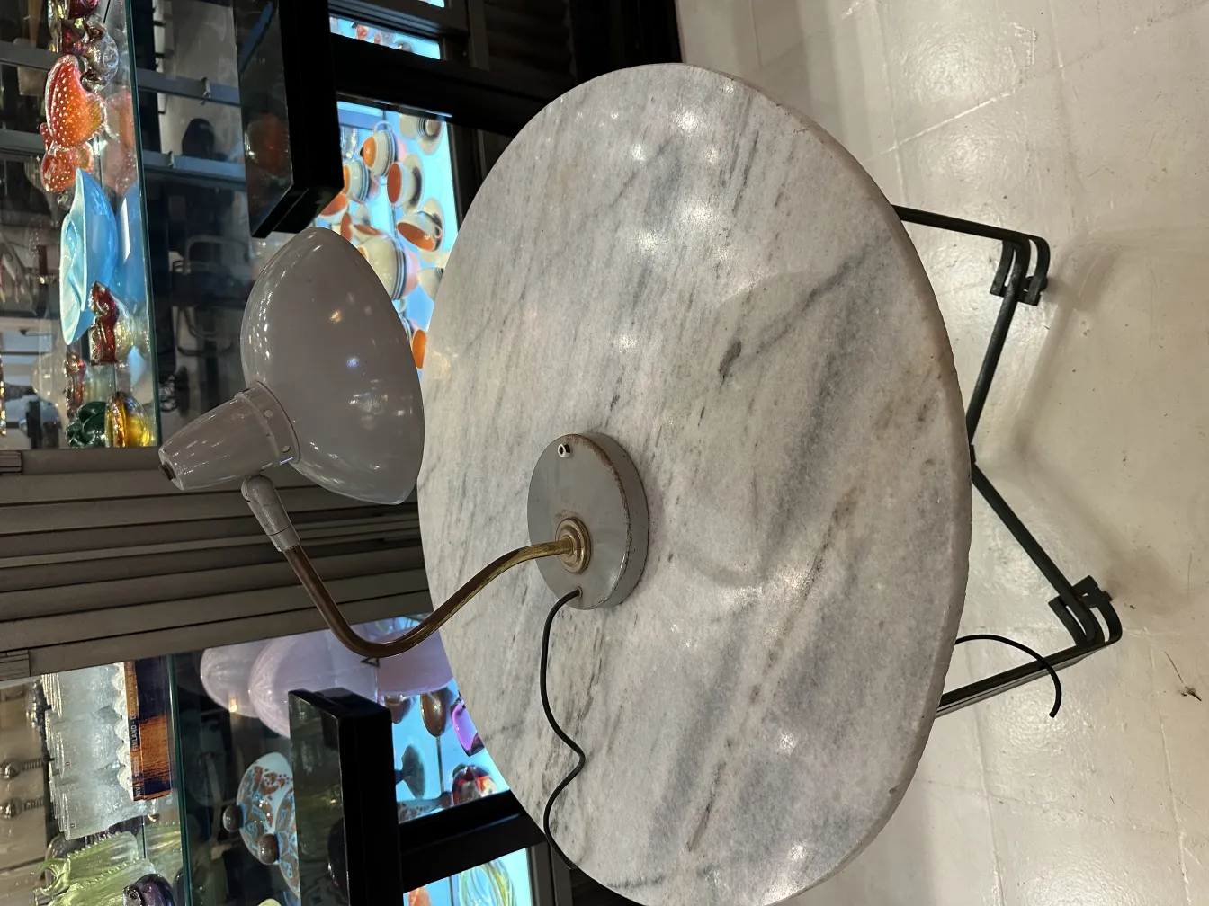 lampe de bureau ancienne avec un design élégant et une base ronde, entourée d'objets décoratifs