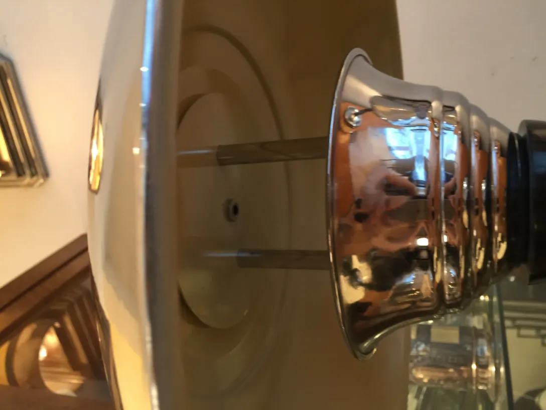 Lámpara de mesa antigua brillante con acabado plateado.