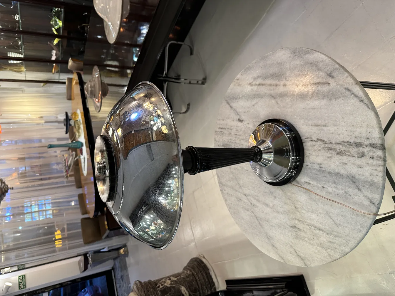 Luminária de mesa antiga com superfície brilhante e design elegante, em um ambiente aconchegante