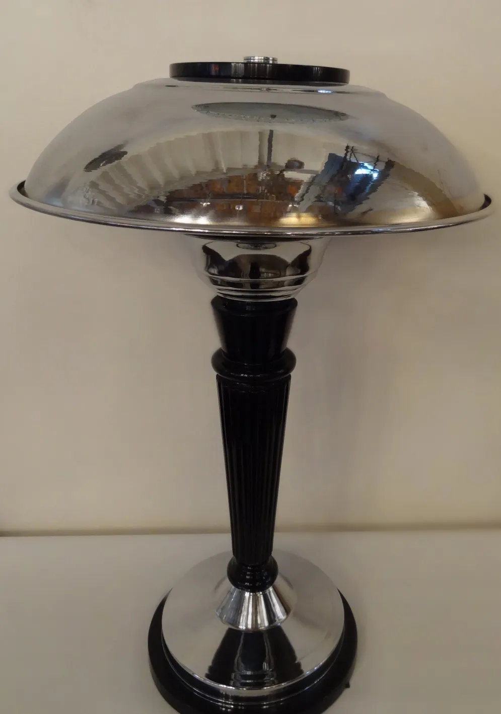 Lampe de bureau antique avec un design élégant et une base brillante dans un cadre simple.