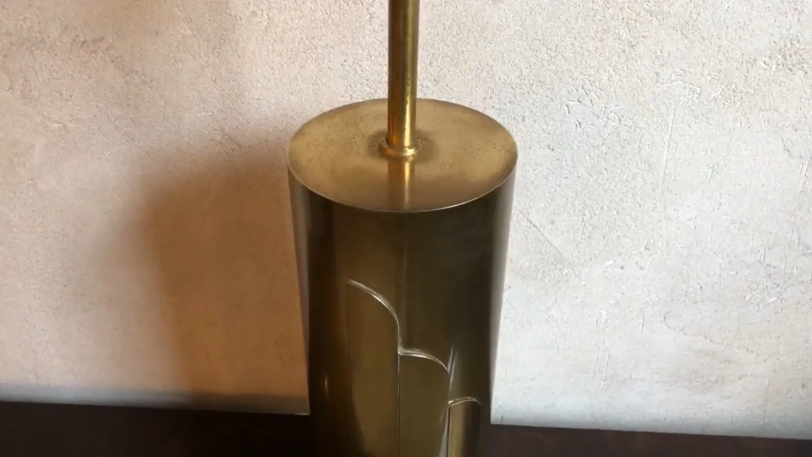 Lámpara de mesa antigua con base redonda y diseño elegante, entorno neutro