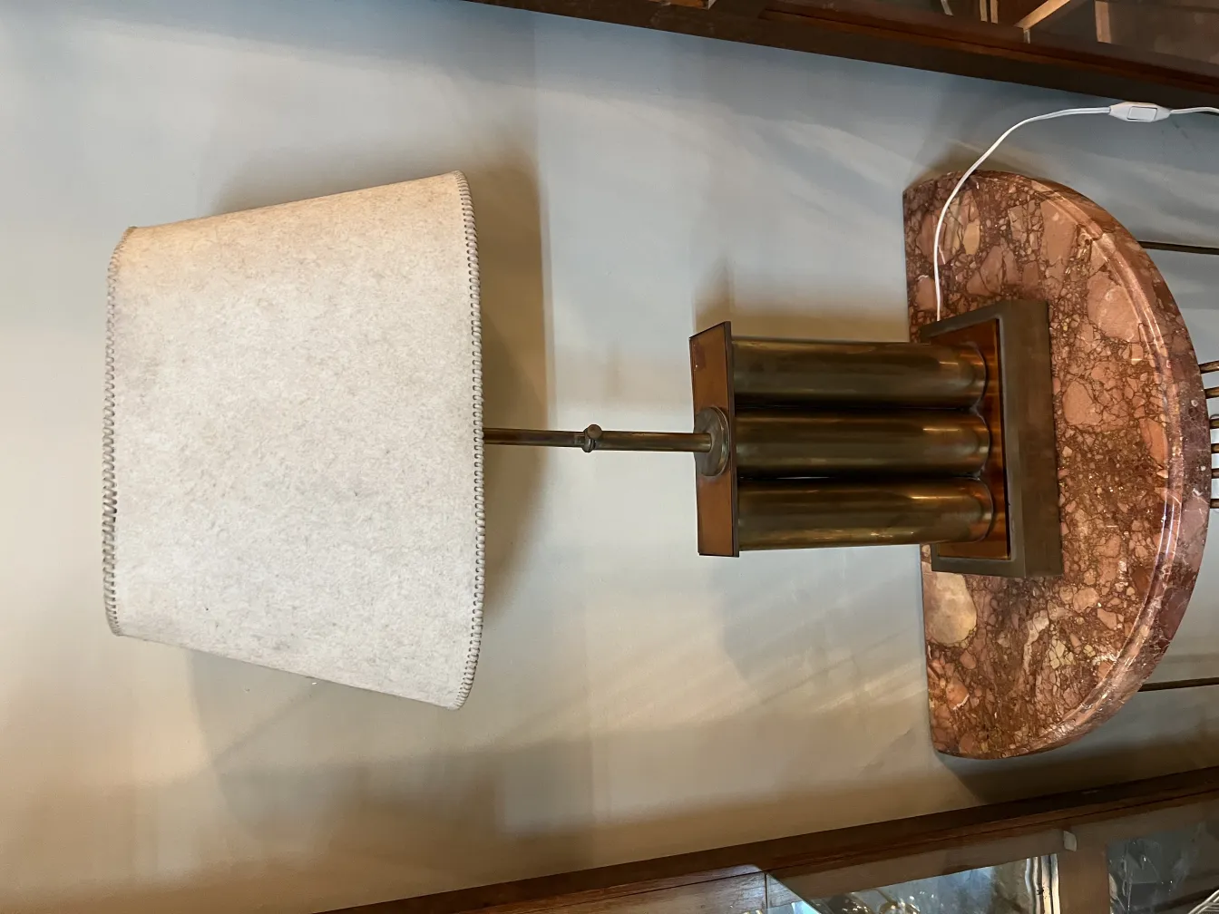 Lampada da tavolo antica con paralume chiaro in un ambiente caldo.