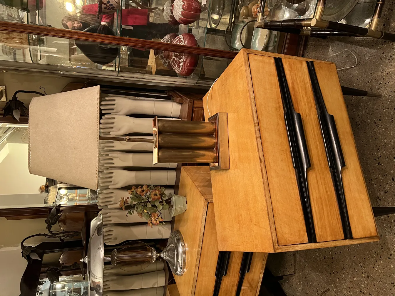 Luminária de mesa antiga com uma cúpula elegante e elementos decorativos ao fundo.