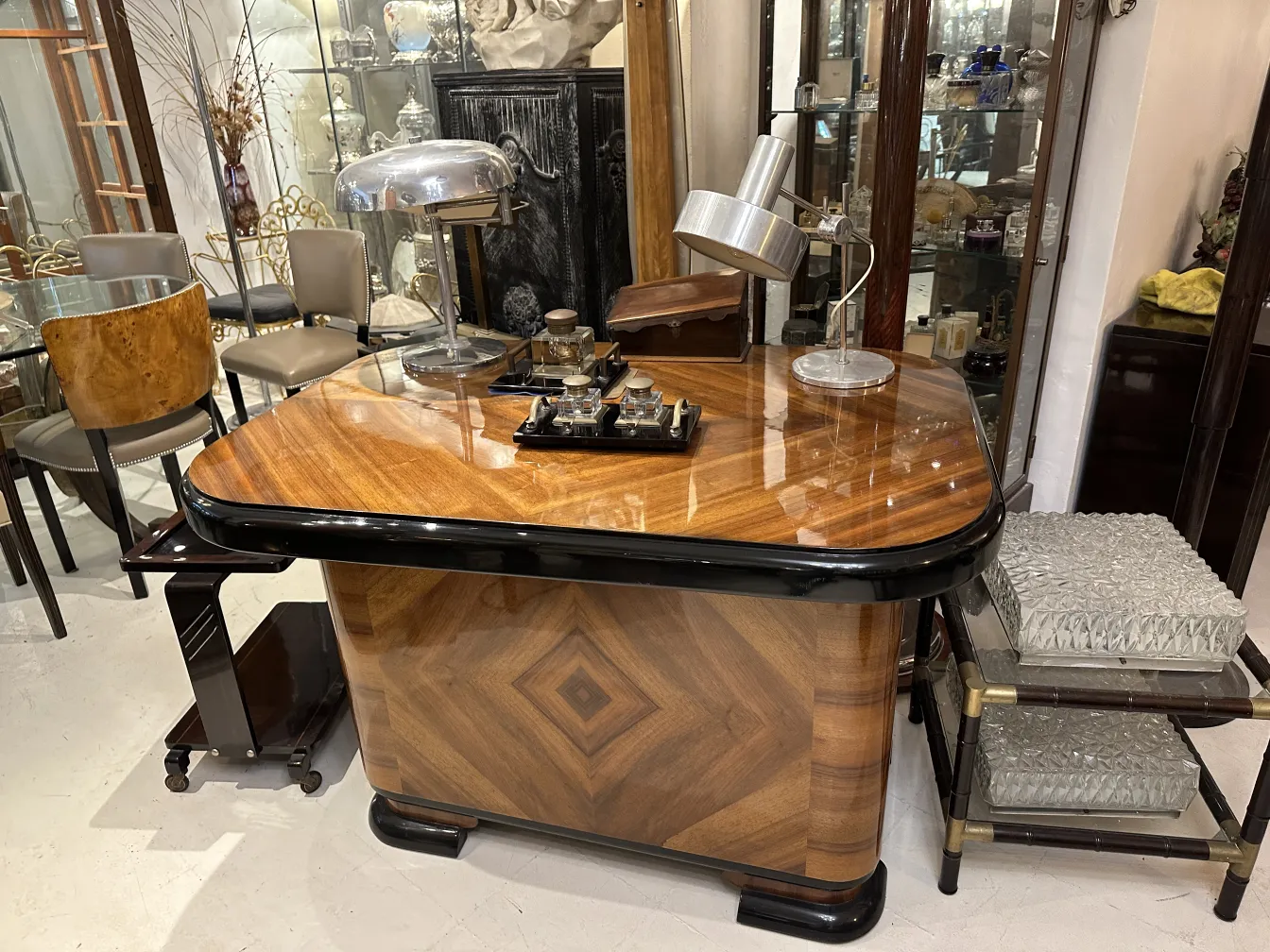 lampada da tavolo antica su un tavolo in legno lucido, circondata da sedie eleganti e un'atmosfera vintage.