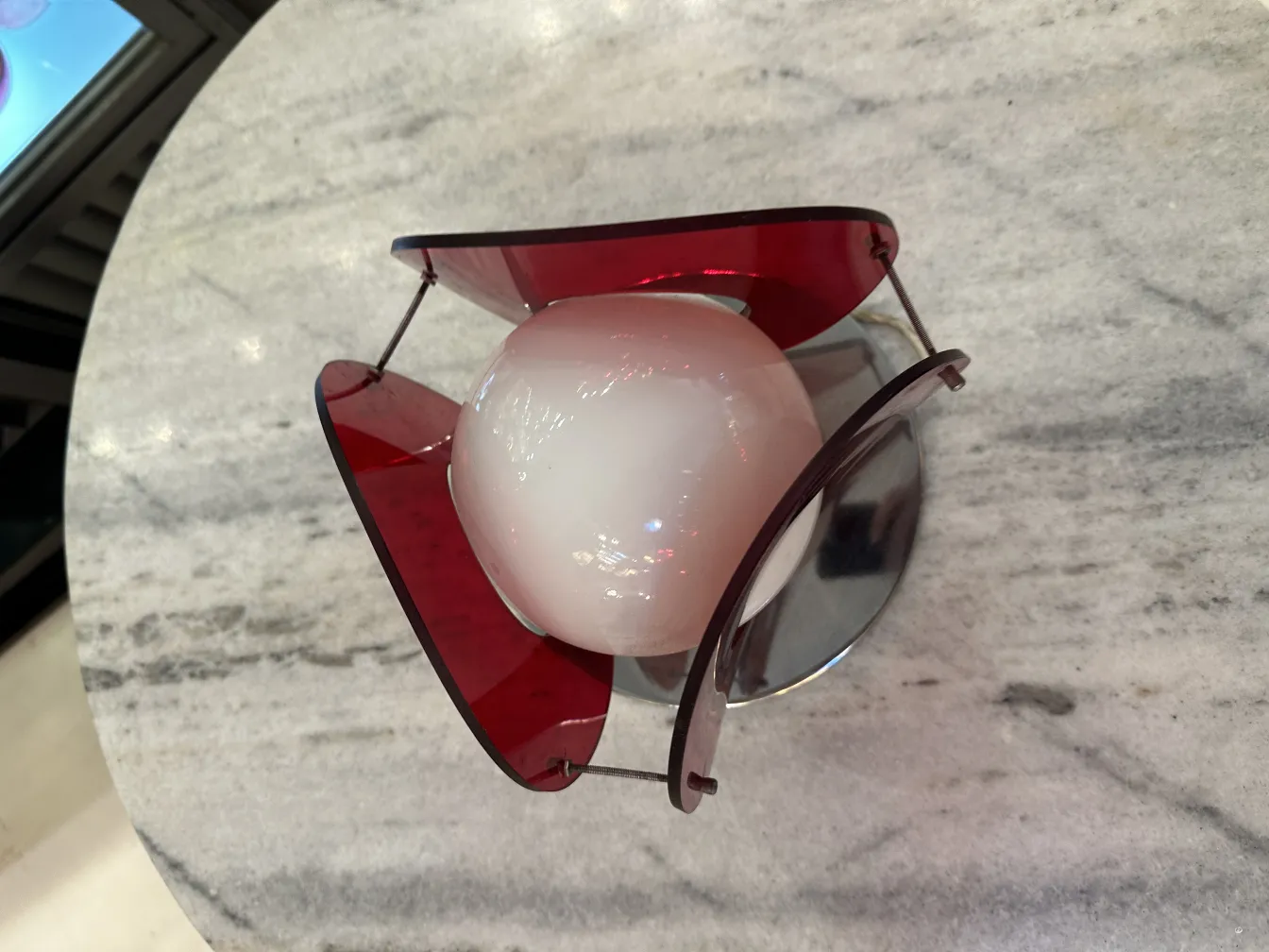 Antike Tischlampe mit buntem Design auf Marmorhintergrund.