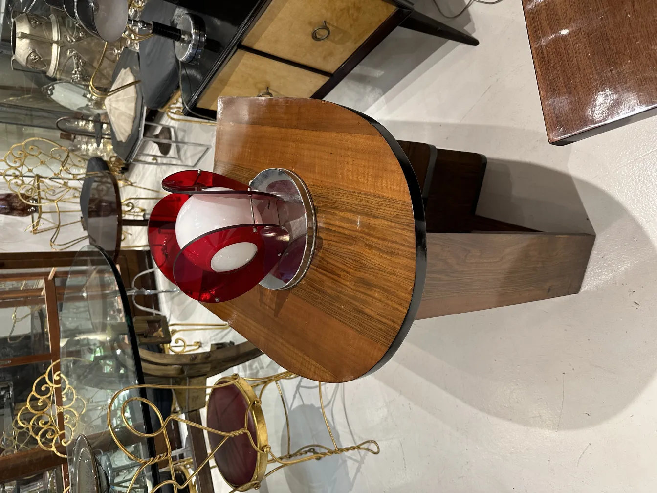 lampe de bureau ancienne avec base rouge et forme ronde, dans un environnement élégant