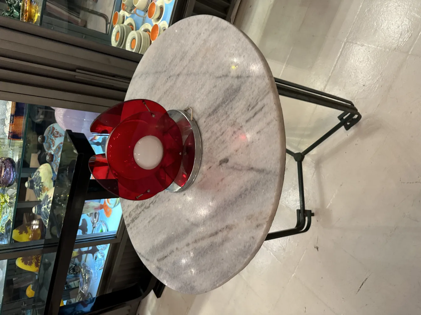 Lampe de bureau antique avec un design rouge sur une table claire.