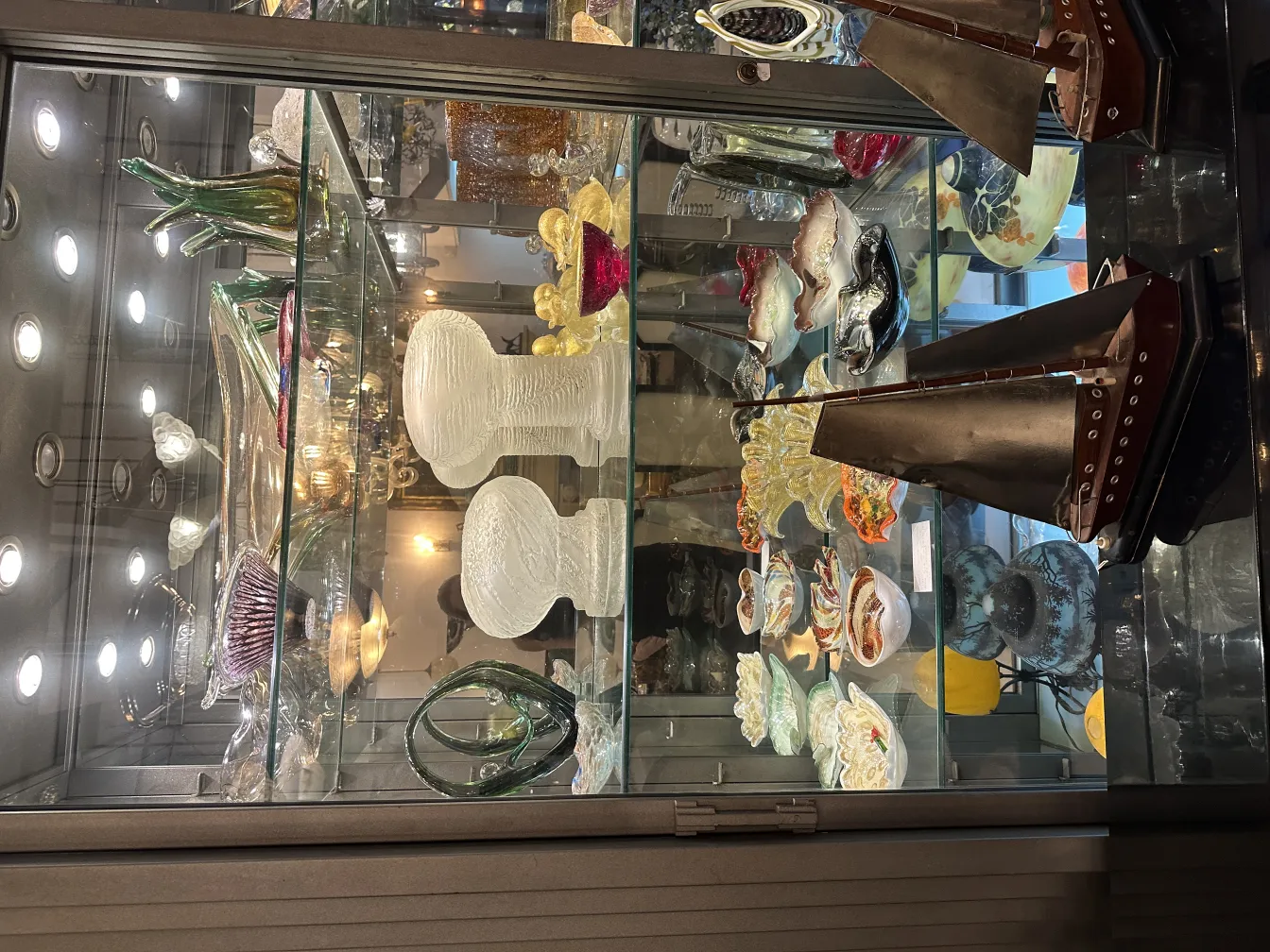 Lampada da tavolo antica con dettagli decorativi, in un ambiente elegante con oggetti in vetro.