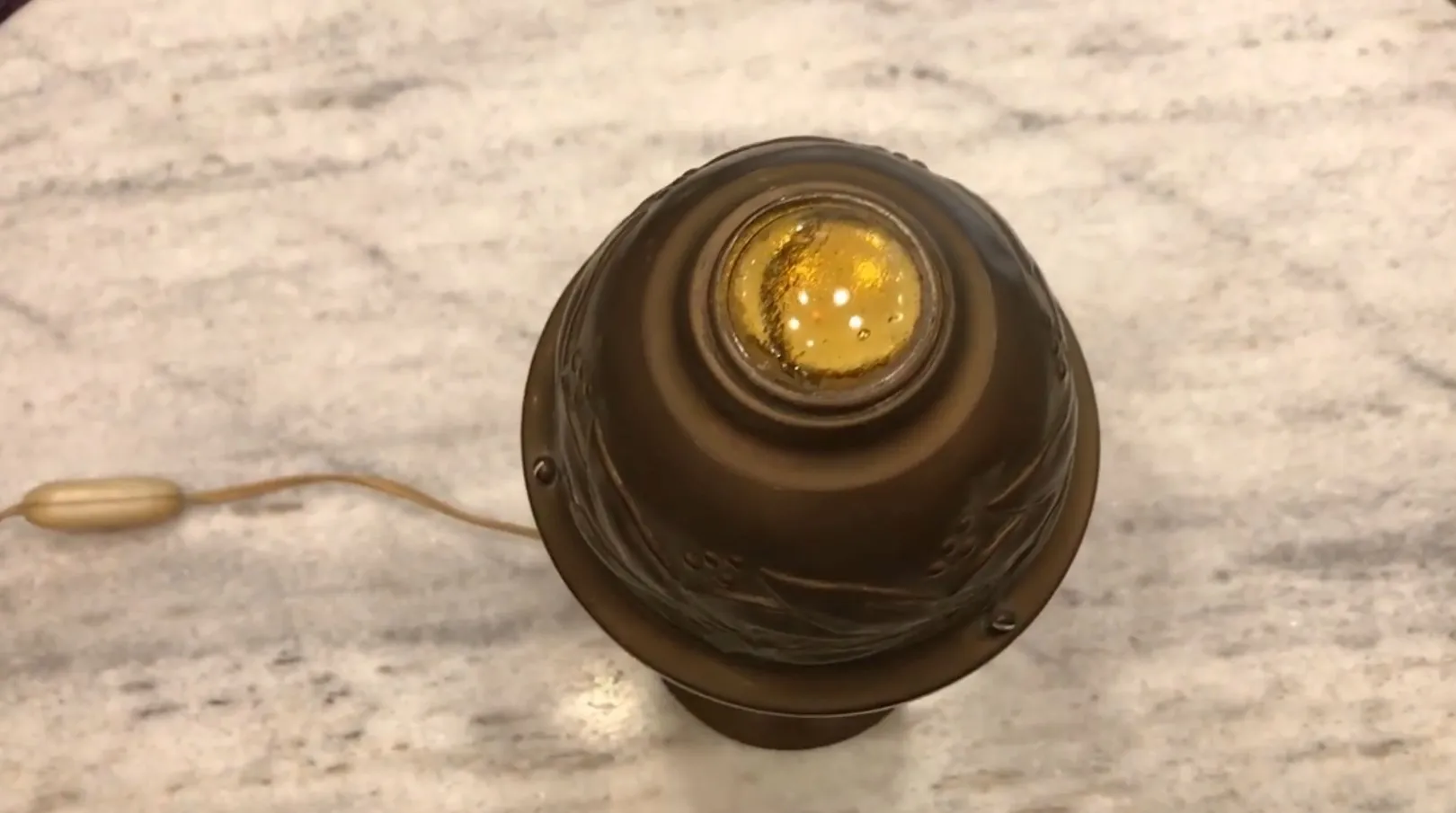 Antike Tischlampe mit gelbem Licht oben.