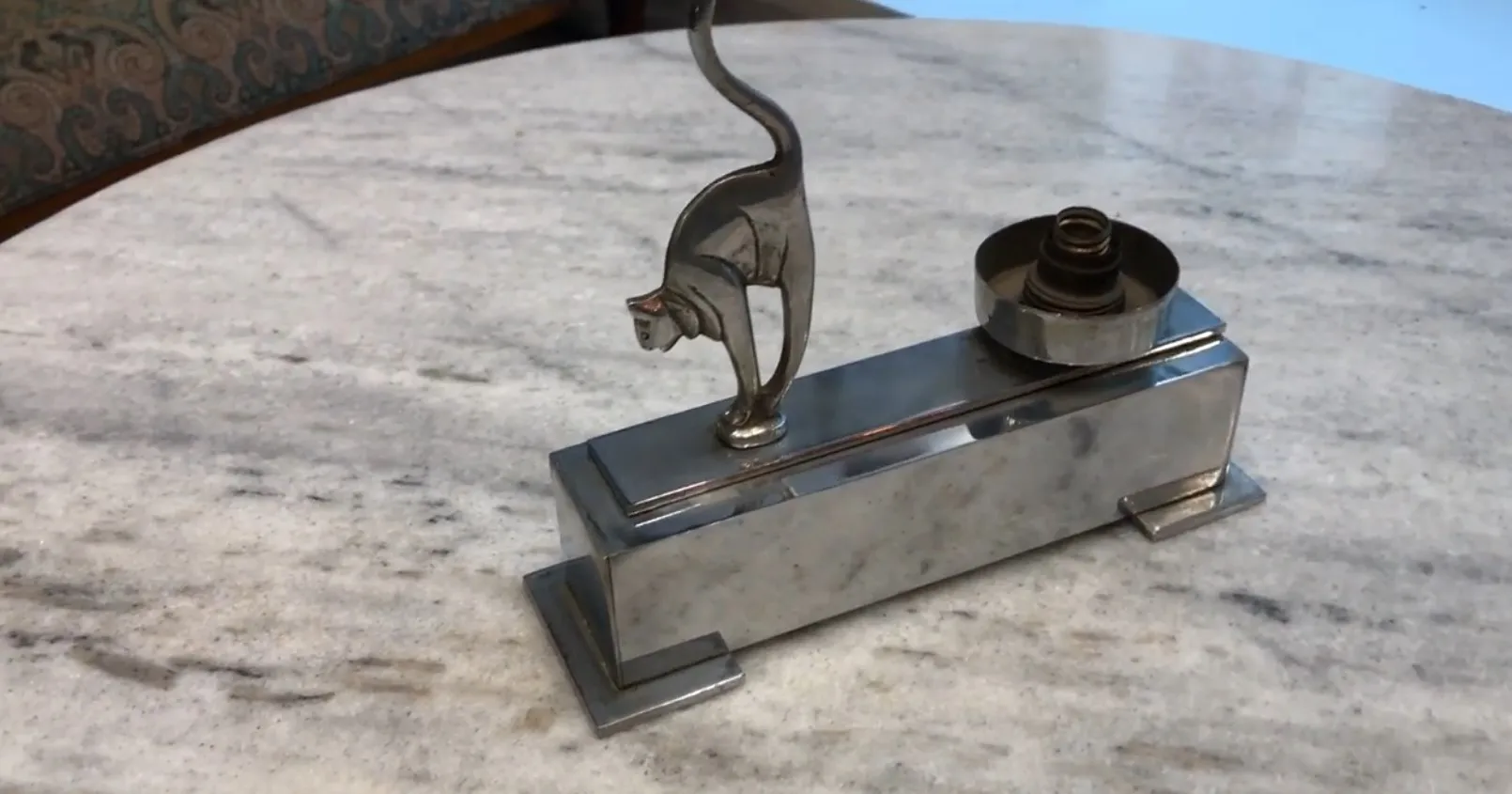 Lampe de bureau ancienne avec un motif de chat, reposant sur une table en marbre.