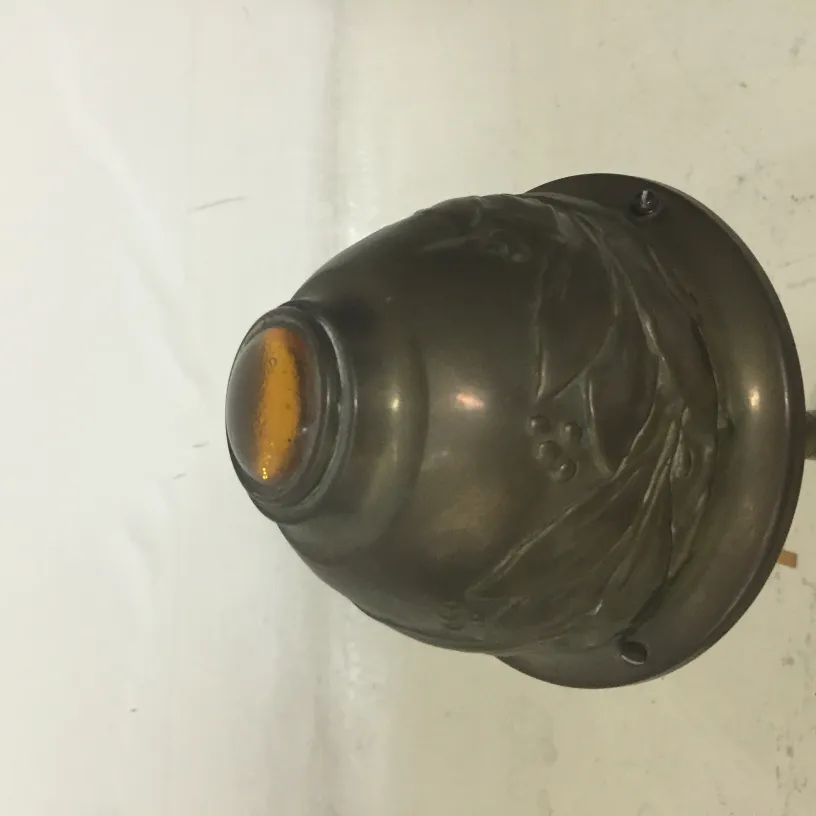 Voici une ancienne lampe de bureau avec des détails décoratifs. Elle a une finition élégante qui améliore sa présence dans n'importe quel cadre.