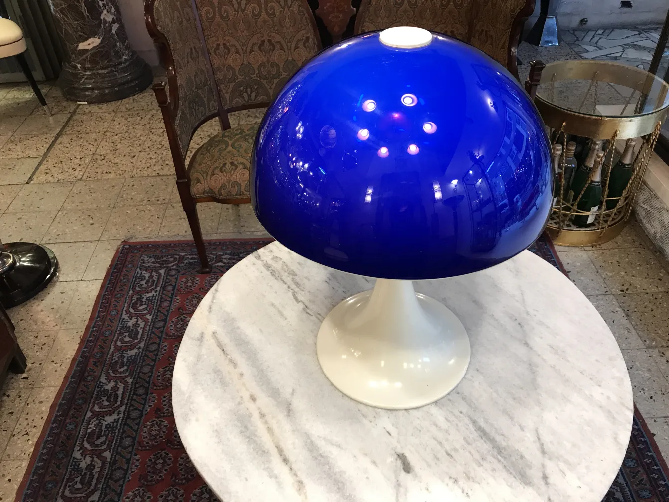 Antigua lámpara de mesa con cúpula azul, ambiente elegante