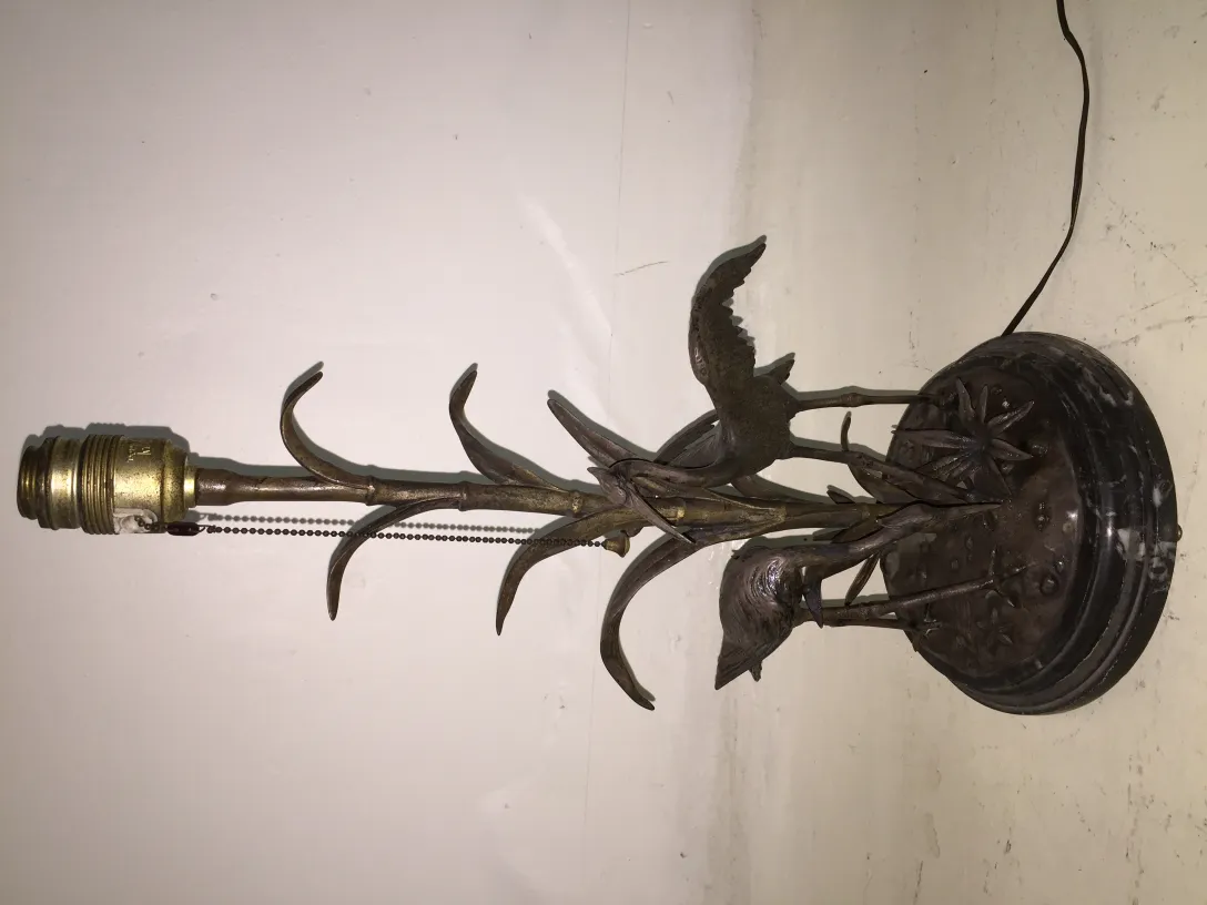 Lampe de bureau antique avec un design d'oiseaux sur une base circulaire.