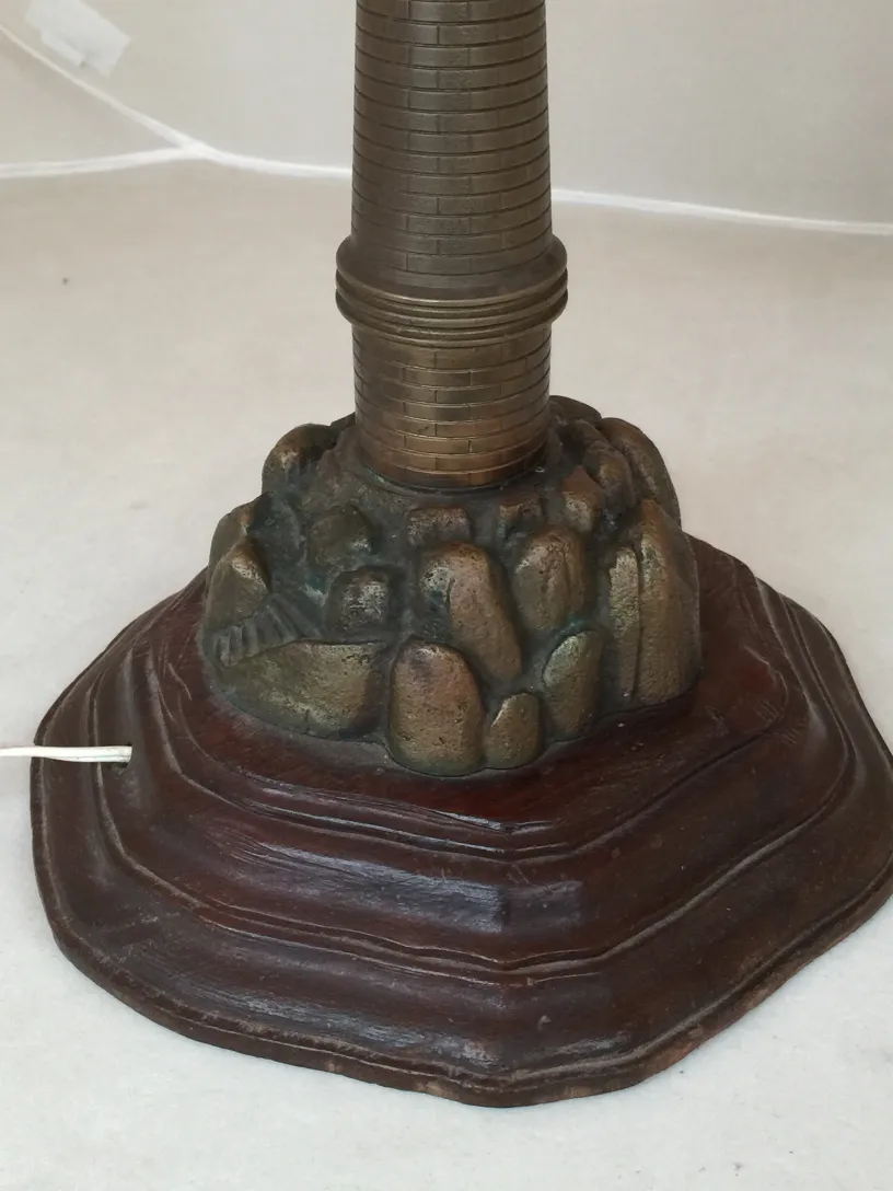 lampada da tavolo antica con base in roccia decorativa, che evidenzia i dettagli inferiori