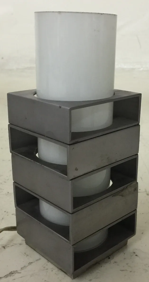 Antique table lamp with geometric design, in a minimalist setting.