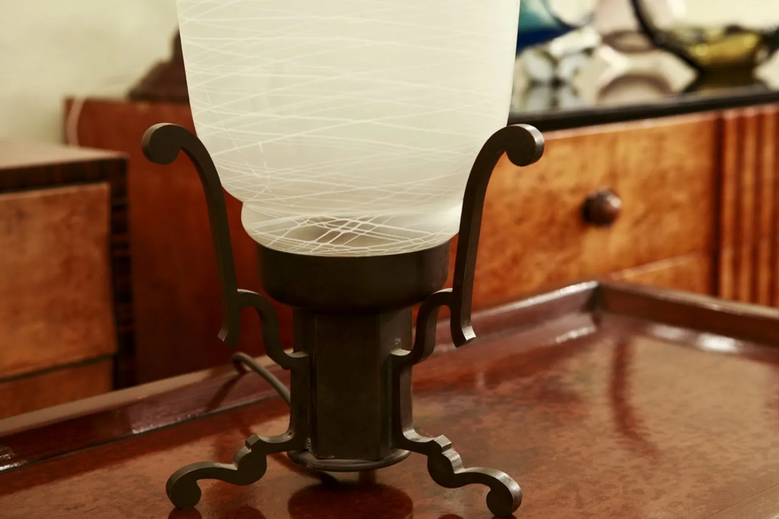 Antique table lamp with decorative base in a cozy setting.