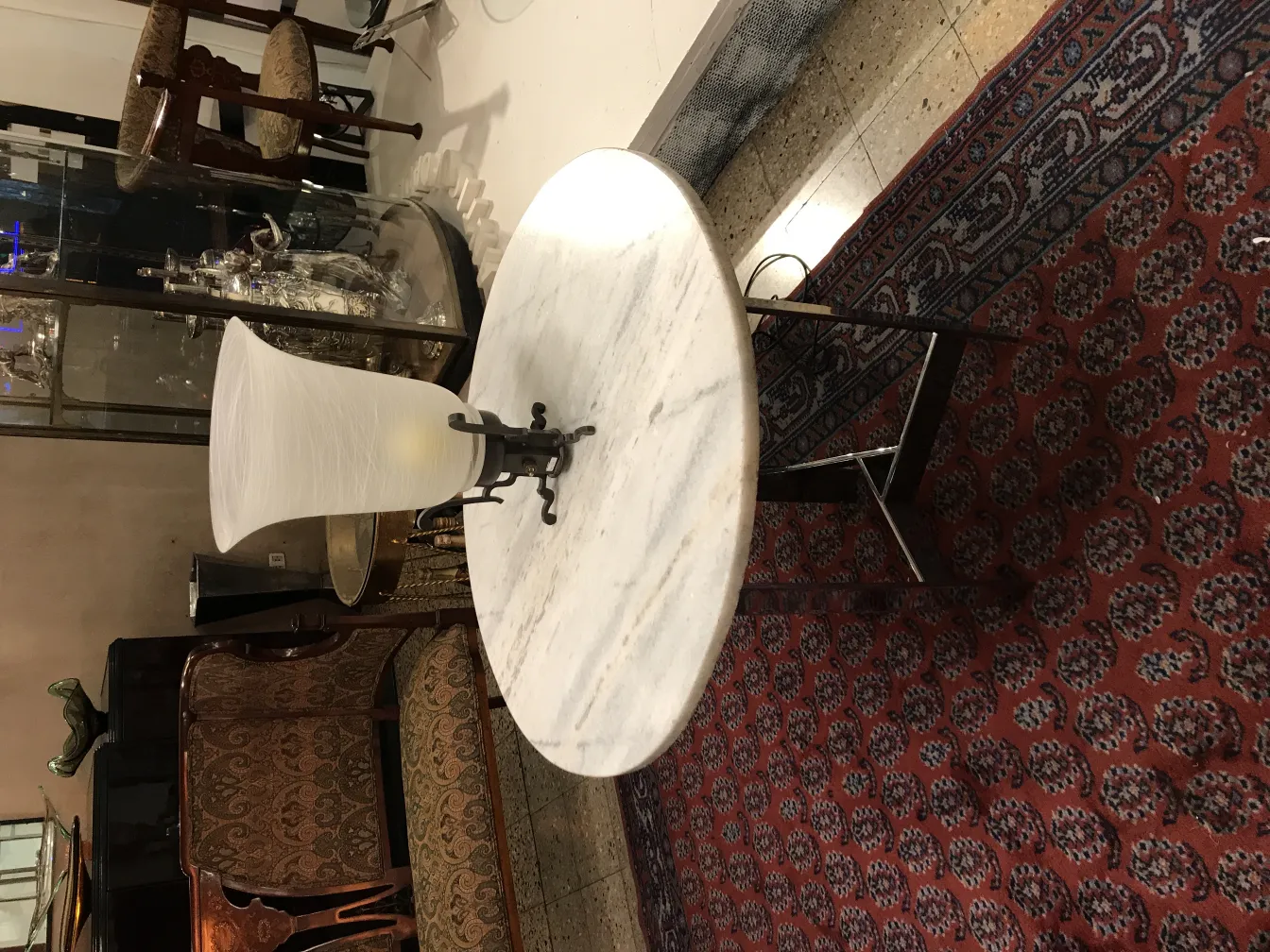 Lampada da tavolo antica con design classico, su uno sfondo decorativo.