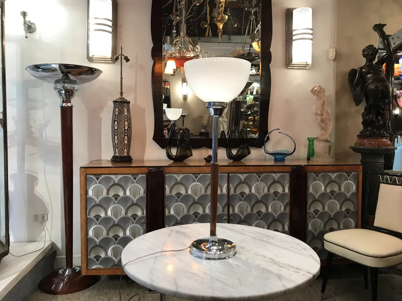 Elegante lampada da tavolo antica accanto a uno specchio con vari oggetti decorativi.