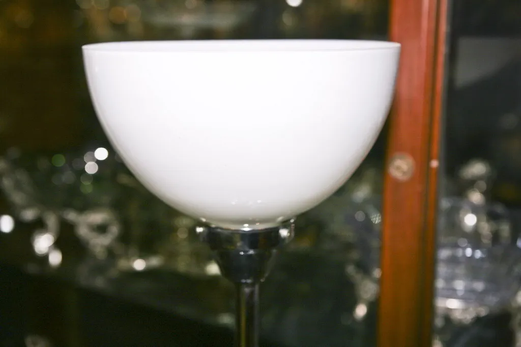 Lampada da tavolo antica bianca con base elegante in un ambiente di antiquariato.