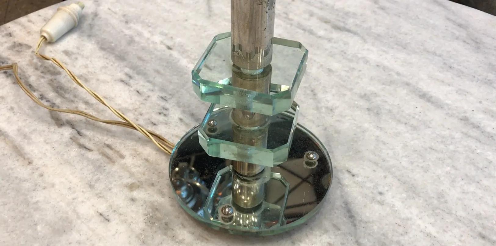 lampada da tavolo antica con forma stilizzata e base decorativa lucida, in un ambiente elegante