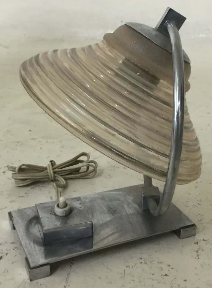 Antique table lamp with curved shade and metal base in a simple setting