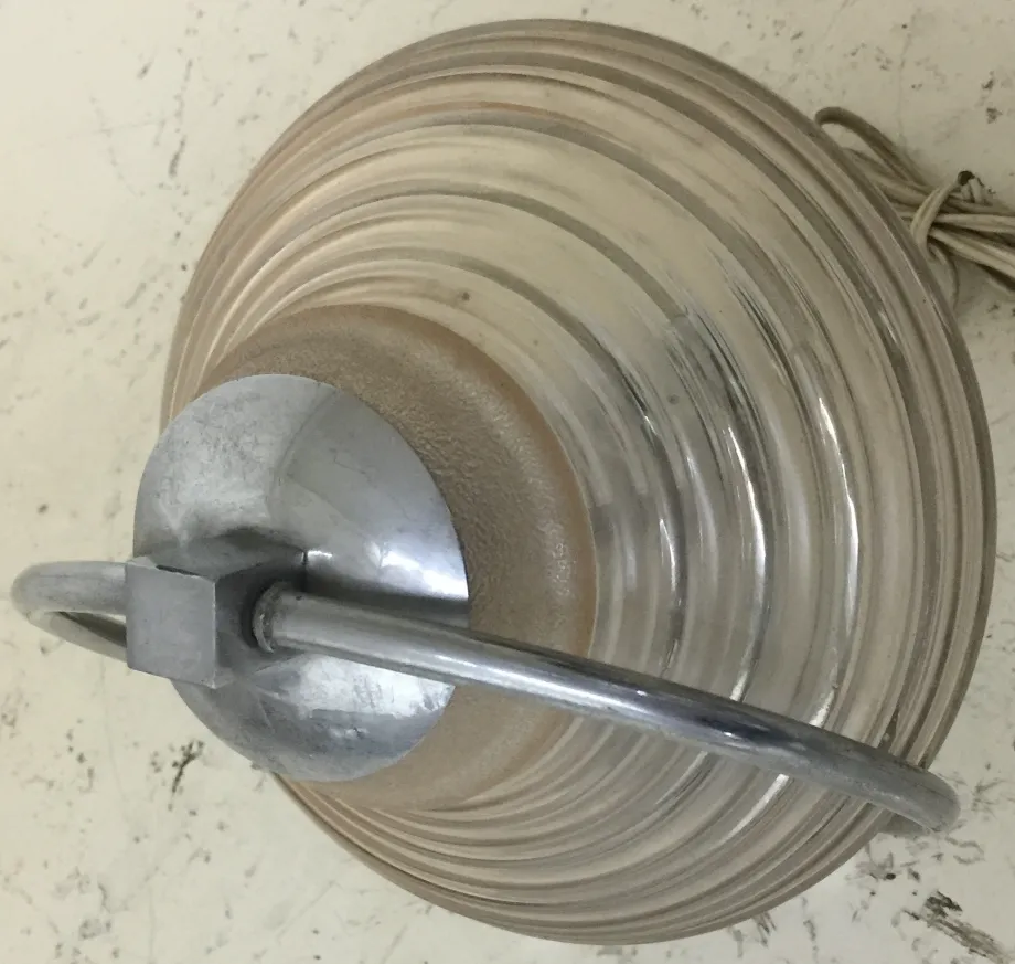 Antique table lamp with elliptical design and metal structure, illuminating the surroundings.