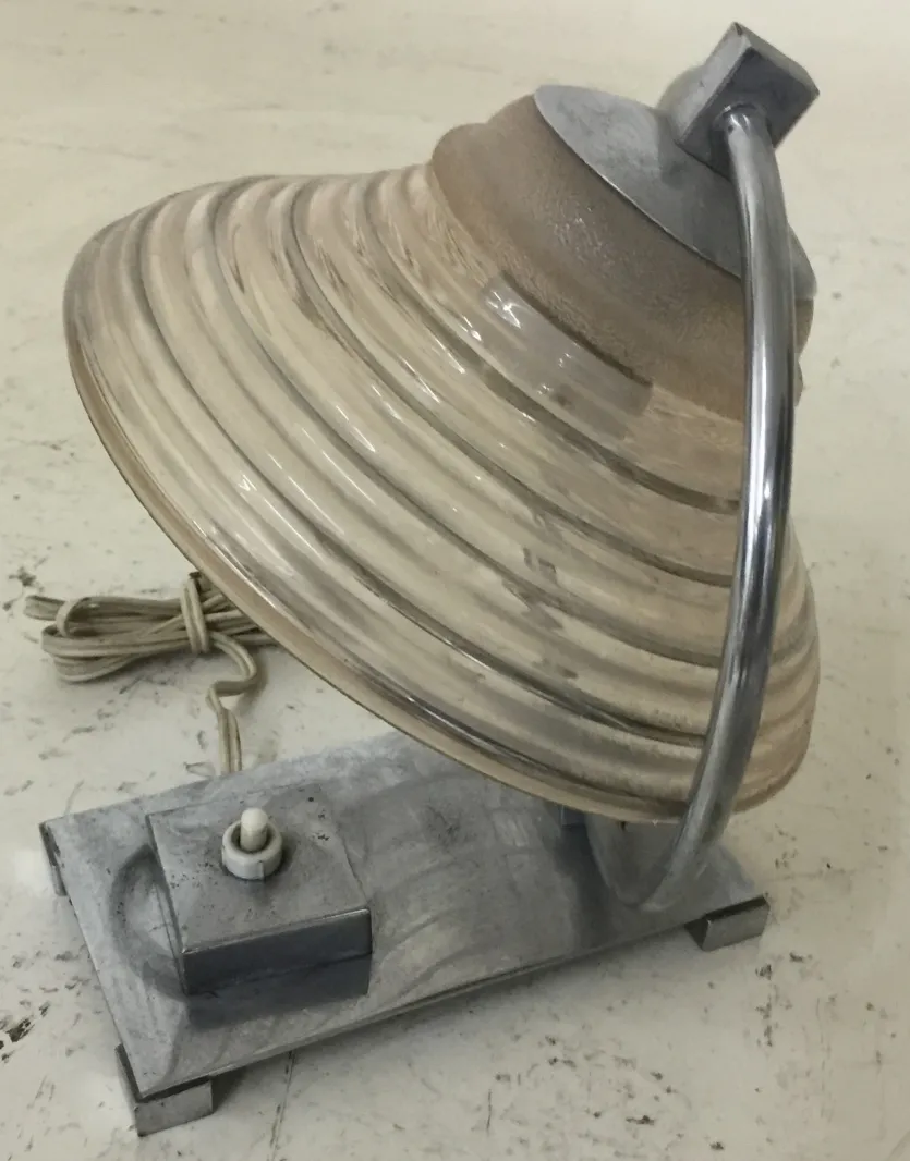 Ancienne lampe de bureau avec un design courbé et une base solide.