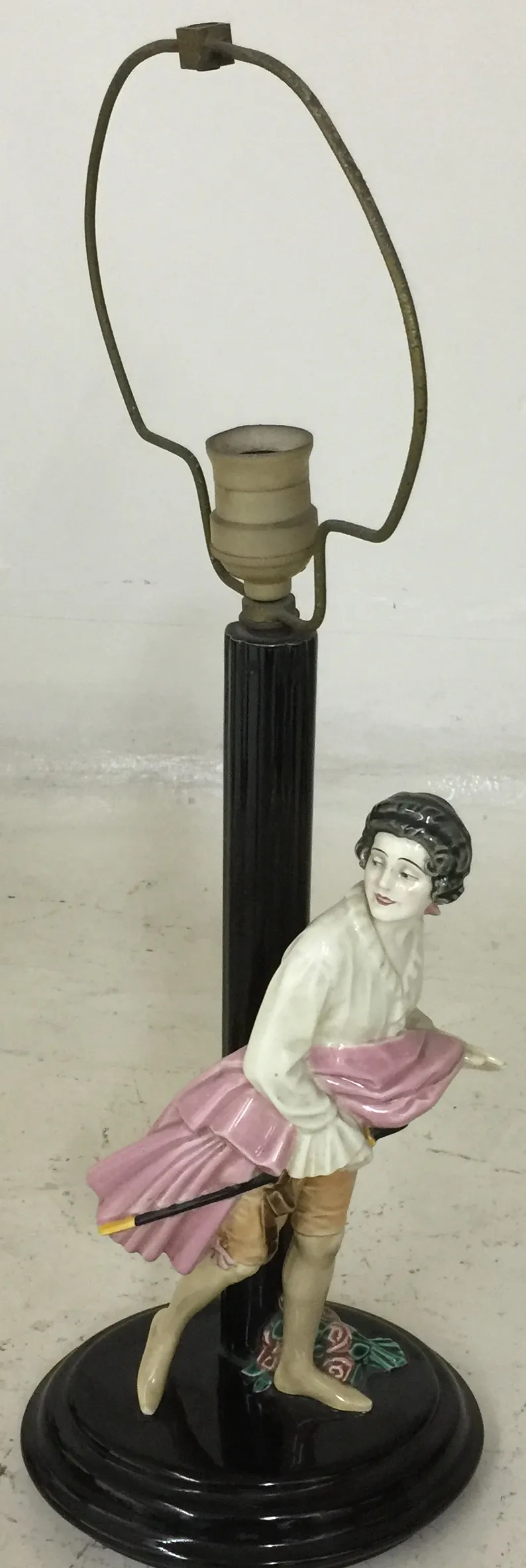 Antique table lamp with decorative figure and black base.