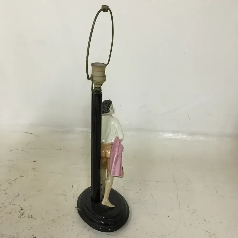 Lampe de bureau ancienne avec figure décorative de Keramos, ambiance chaleureuse.