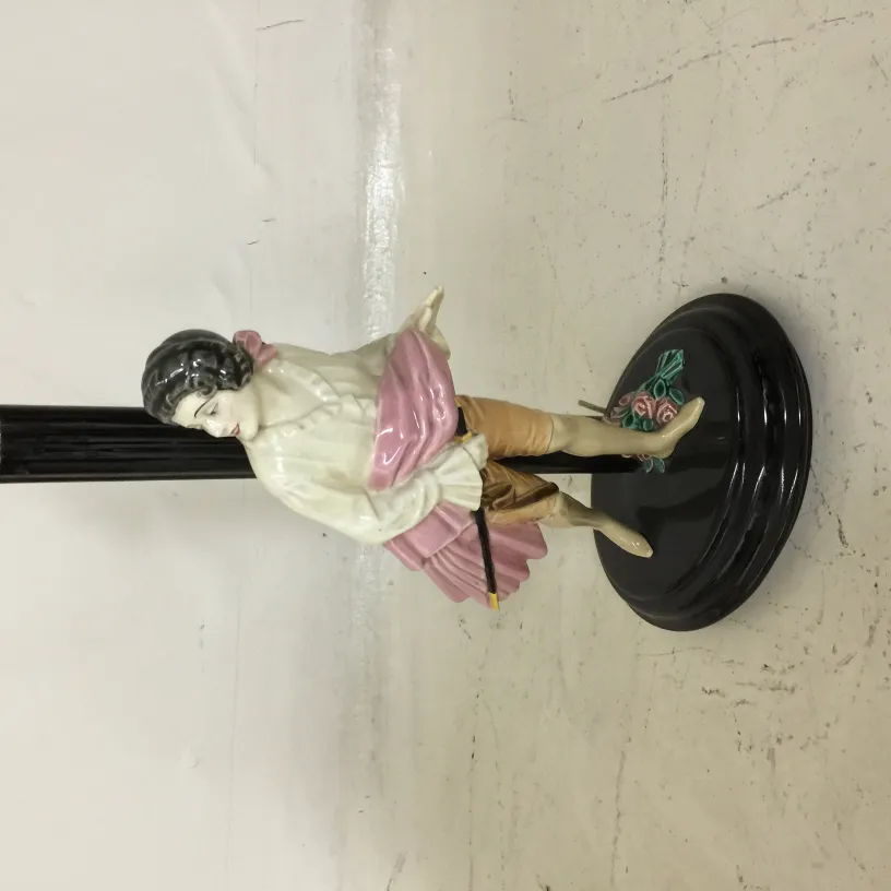 Antique table lamp featuring a decorative figure and colorful details.