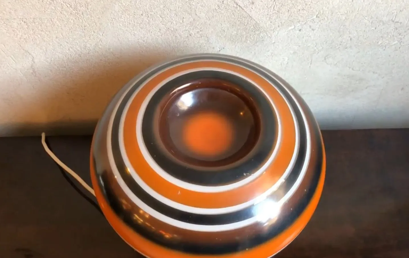 古董台灯，带有圆形设计和鲜艳的颜色，放在木质表面上