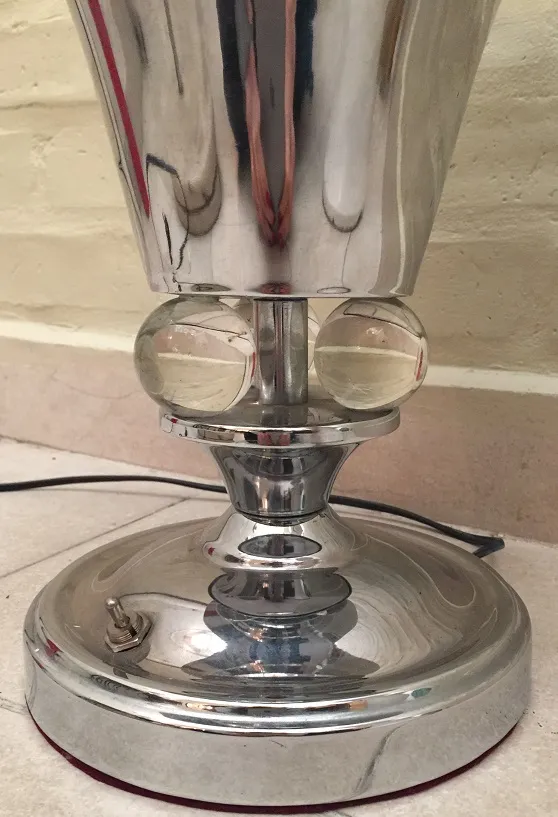 Antique bright table lamp with spherical details and polished base.