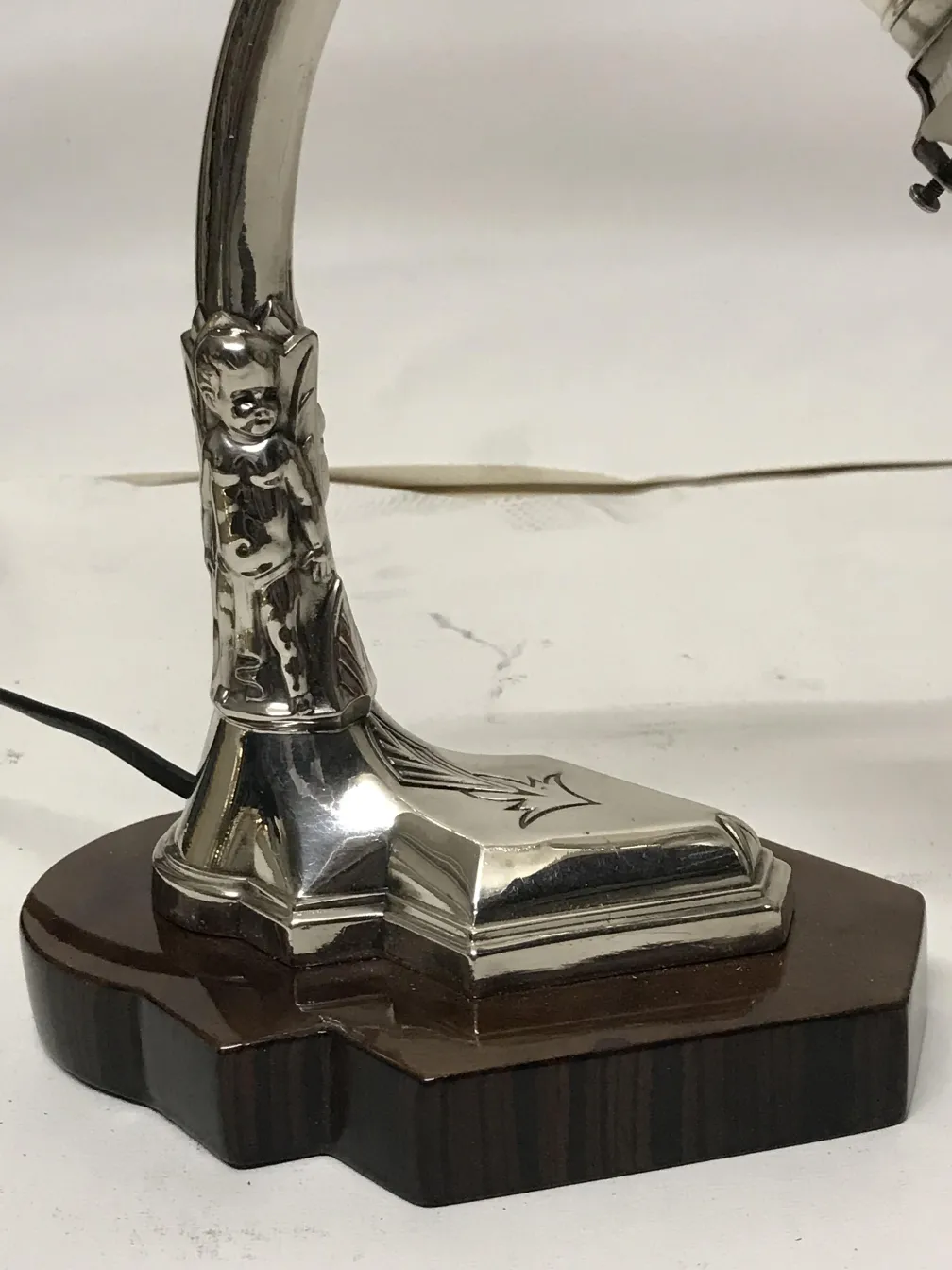 Lampada da tavolo antica con base a campana, dettagli decorativi e finiture lucide, ambiente accogliente.