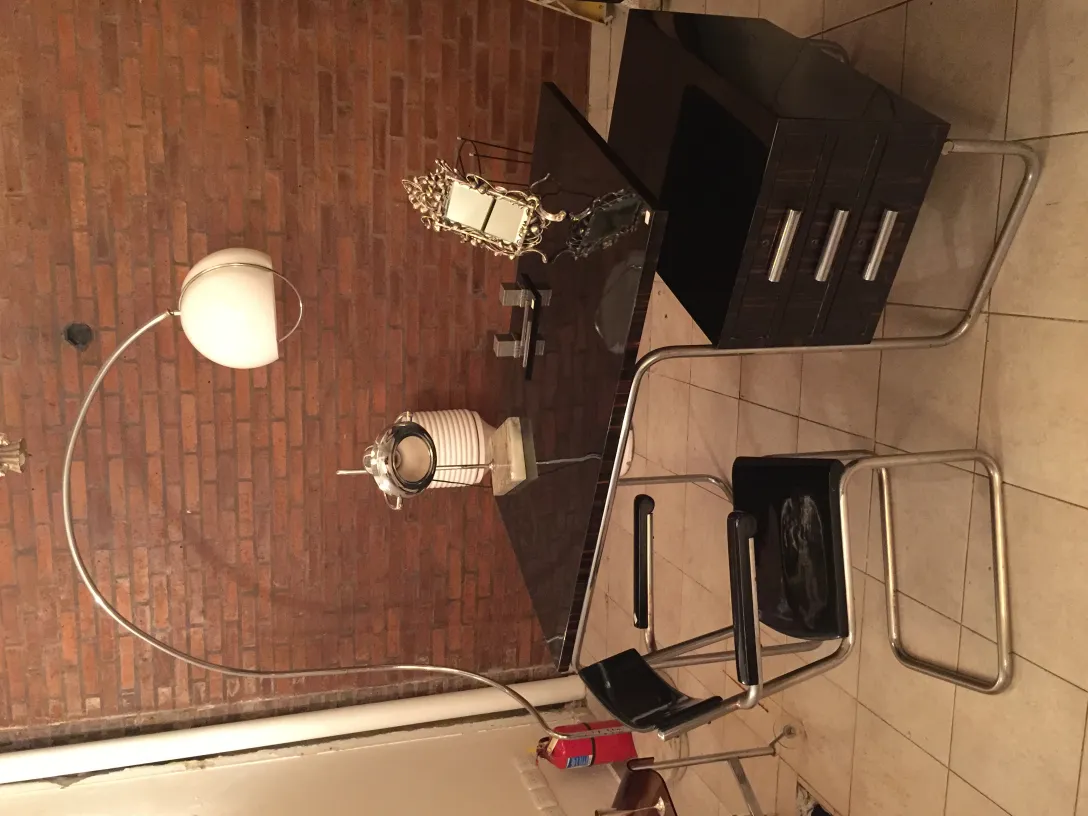 Lámpara de mesa antigua con un acabado elegante, ubicada en un entorno moderno y minimalista, destaca en la sala.