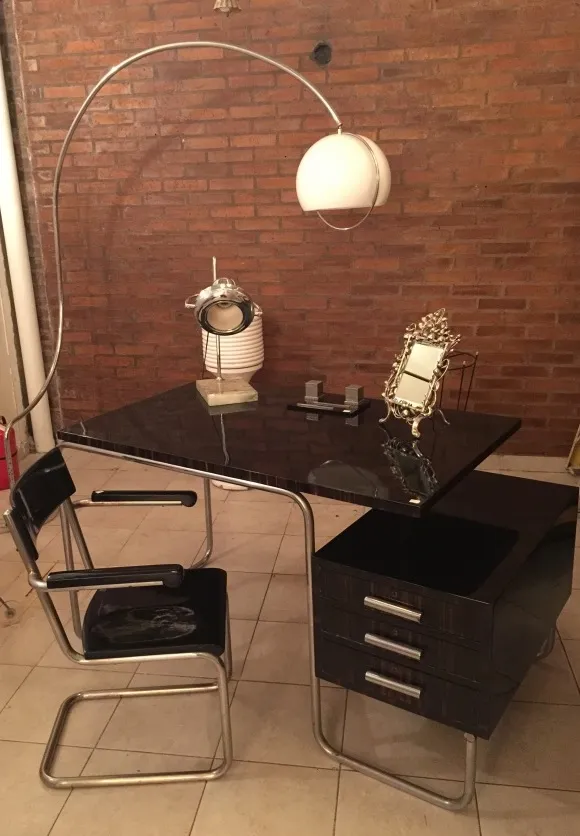 luminaria de mesa antiga com base elegante e luz suave em uma mesa moderna, cercada por acessórios de escritório