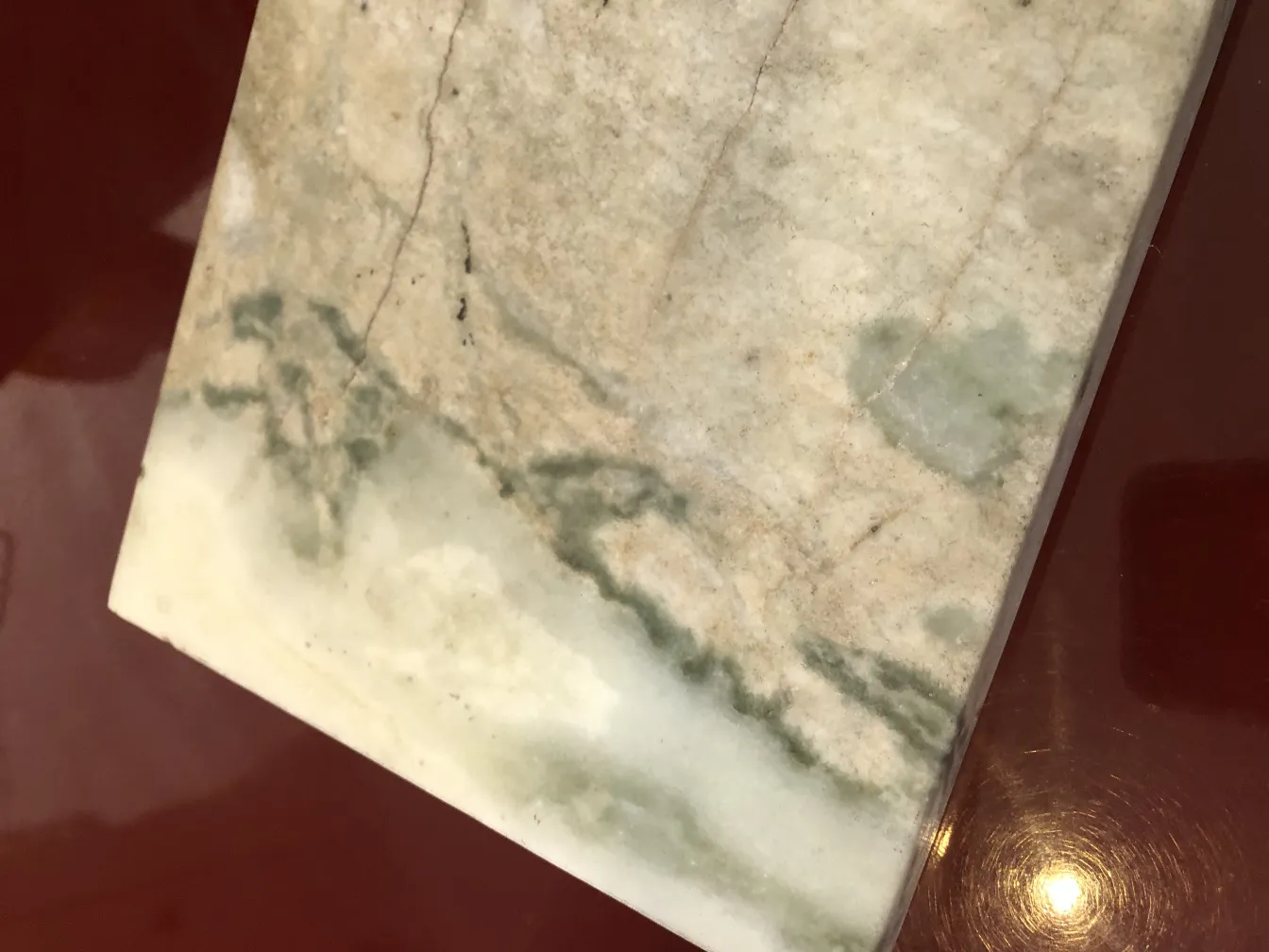 Antiga luminária de mesa com base decorativa e detalhes verdes, ambiente aconchegante