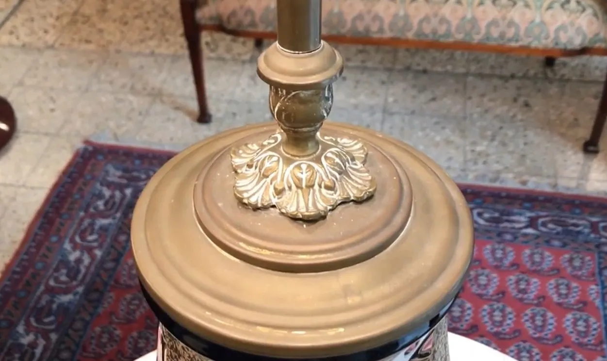 Antike Tischlampe mit dekorativer Basis und verziertem Design in klassischem Ambiente