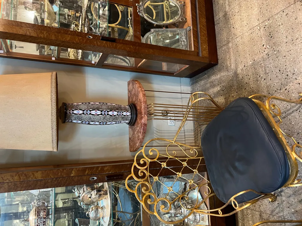 antik-tischlampe-mit-beigem-schirm-und-dekoriertem-sockel-in-einer-antiquitaet-umgebung