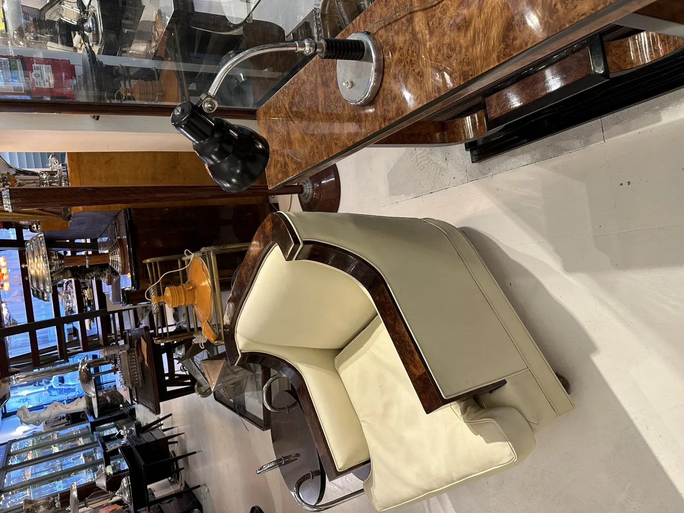 Lampe de bureau noire antique sur une table en bois, avec une chaise en arrière-plan.