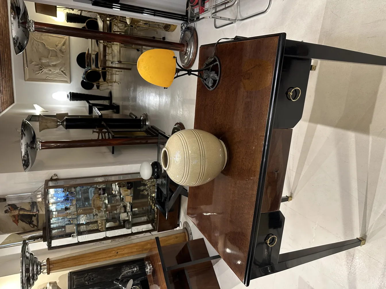 Antigua lámpara de mesa amarilla en un ambiente acogedor con objetos decorativos.