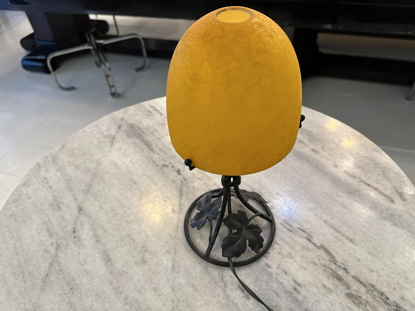 Antique table lamp with yellow shade, elegant design, on marble table