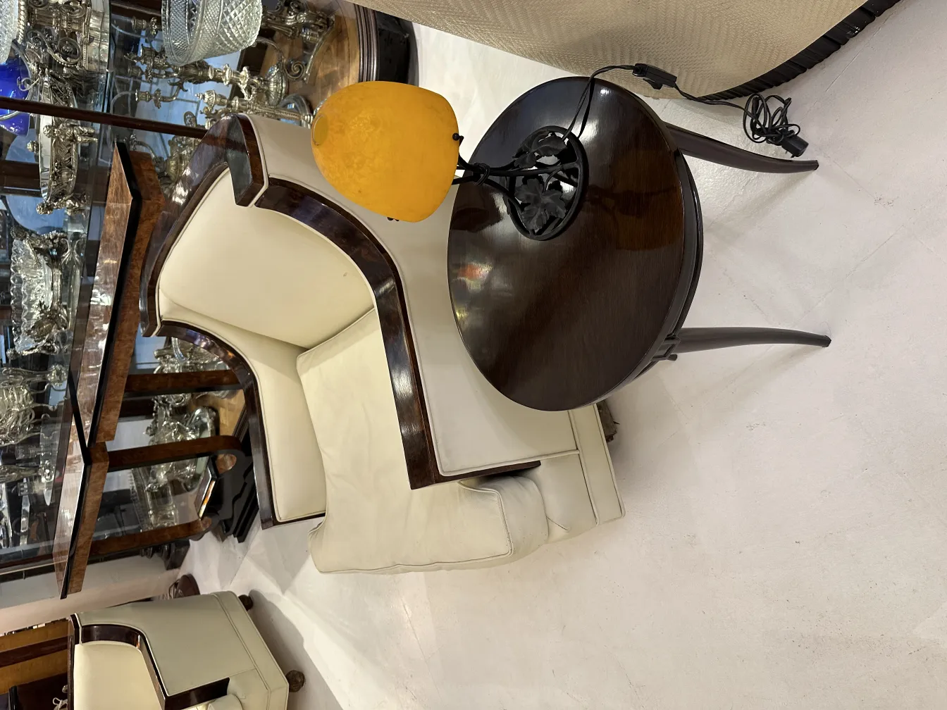 Lampe de bureau ancienne avec abat-jour rond sur une table en bois, ambiance élégante.