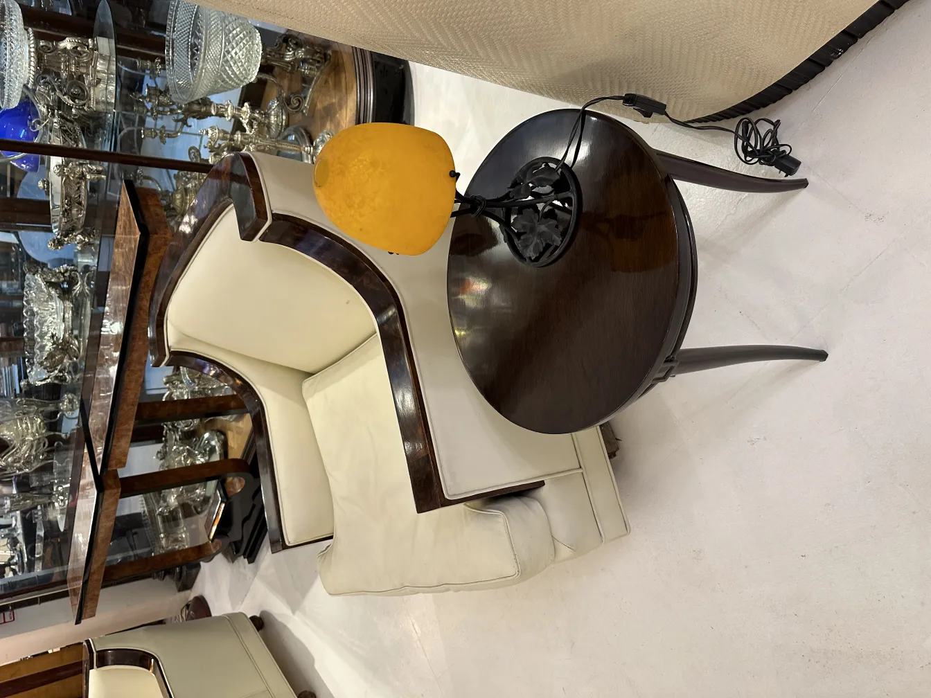 مصباح طاولة قديم بقائمة سوداء وشاشة صفراء، إضاءة ناعمة في بيئة أنيقة.