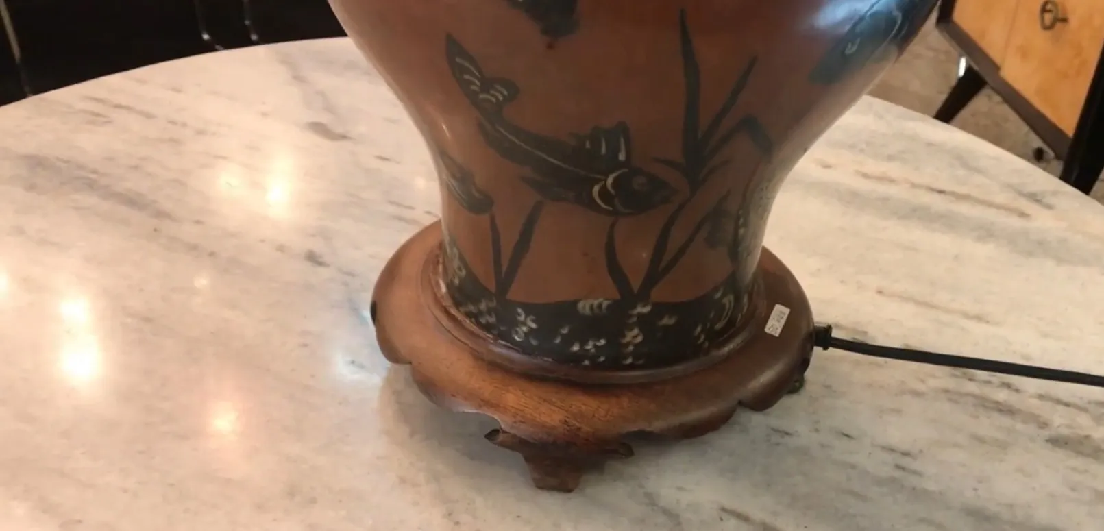 Antique table lamp with a wooden base and fish design.