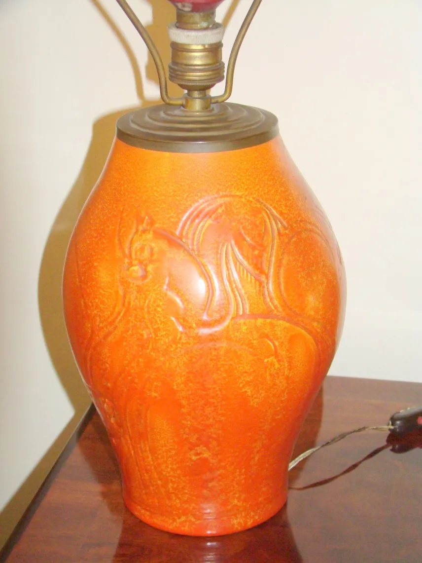 Antike Tischlampe in orange mit dekorativem Design.