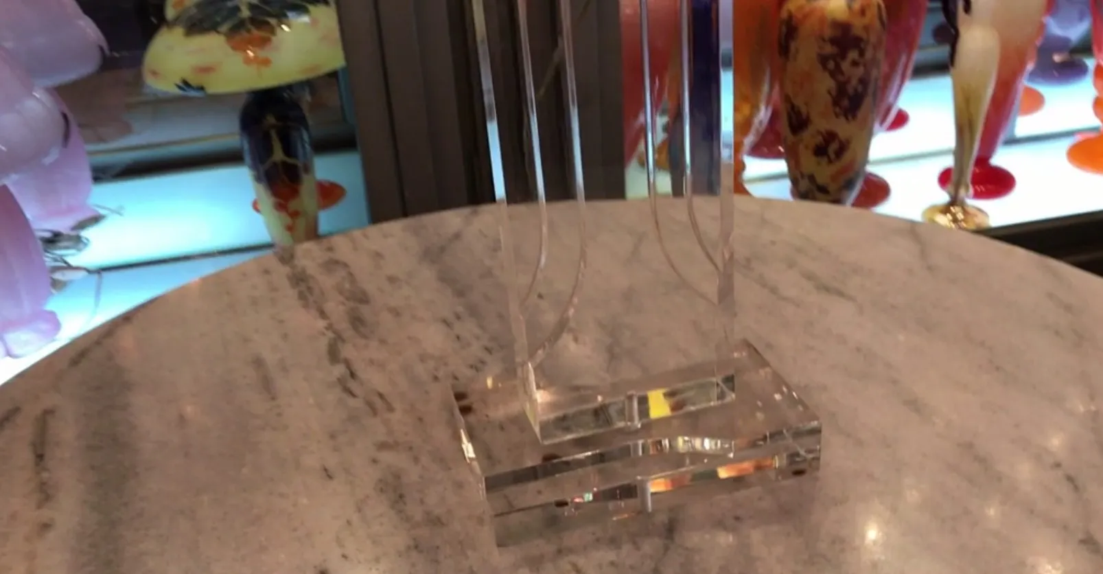 Lampe de bureau antique avec base transparente sur une table.