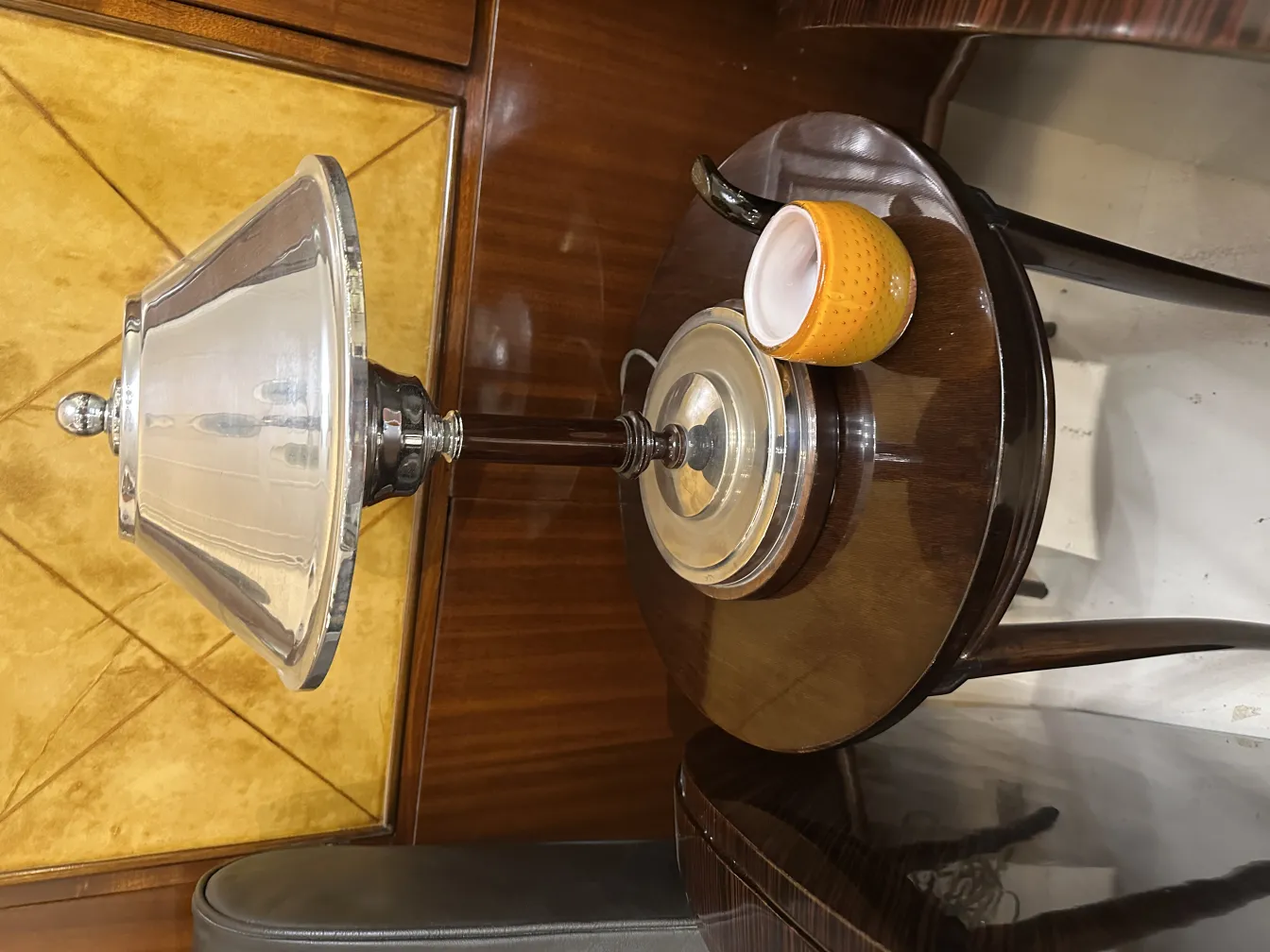 antike Tischlampe mit konischem Schirm und glänzender Basis, neben einer Tasse