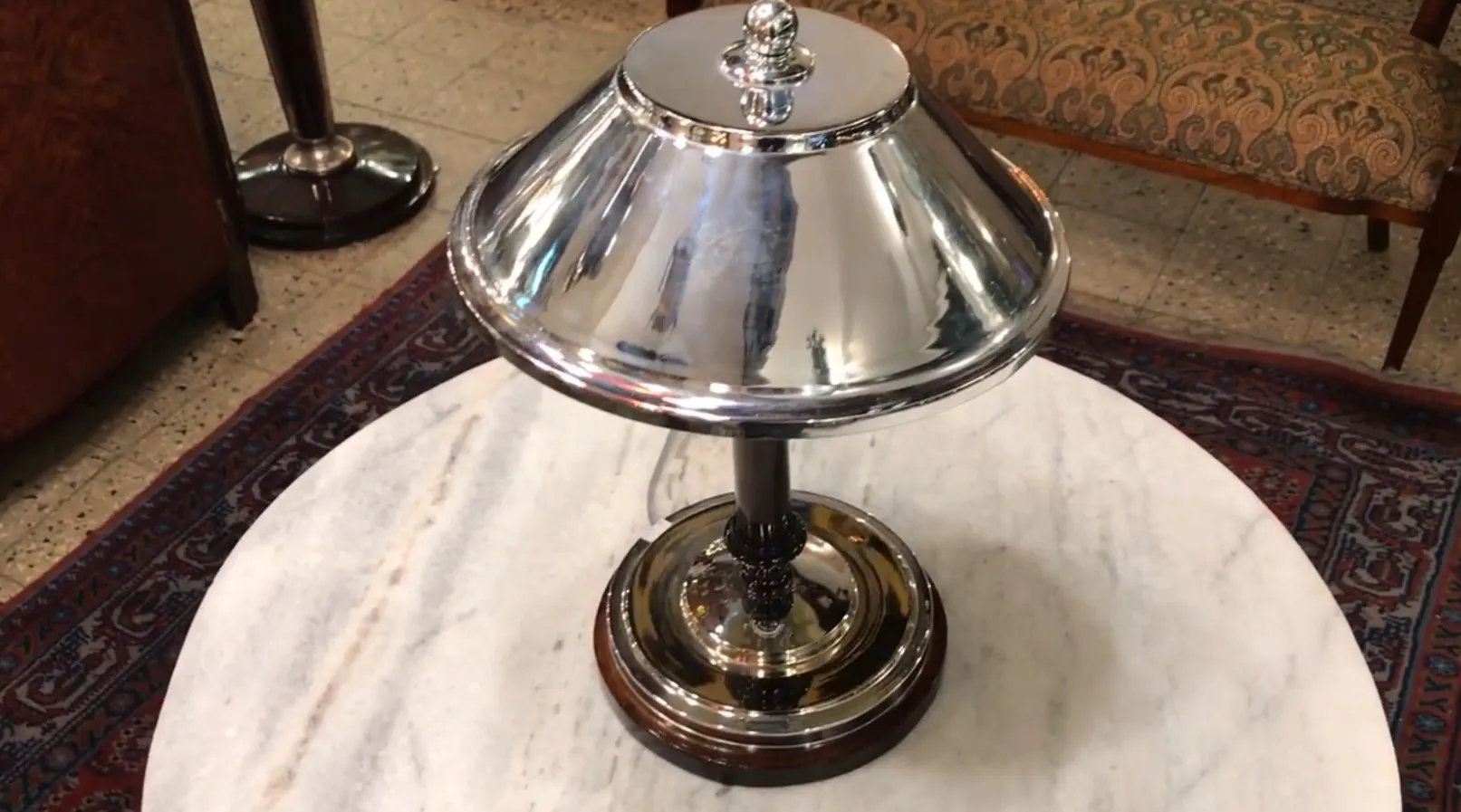 Antique table lamp with a shiny base, in a cozy setting.