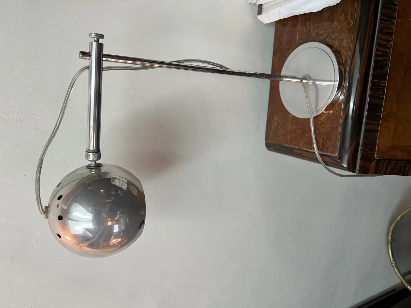 Lampe de bureau ancienne avec un design sphérique et élégant, placée sur un meuble décoratif.