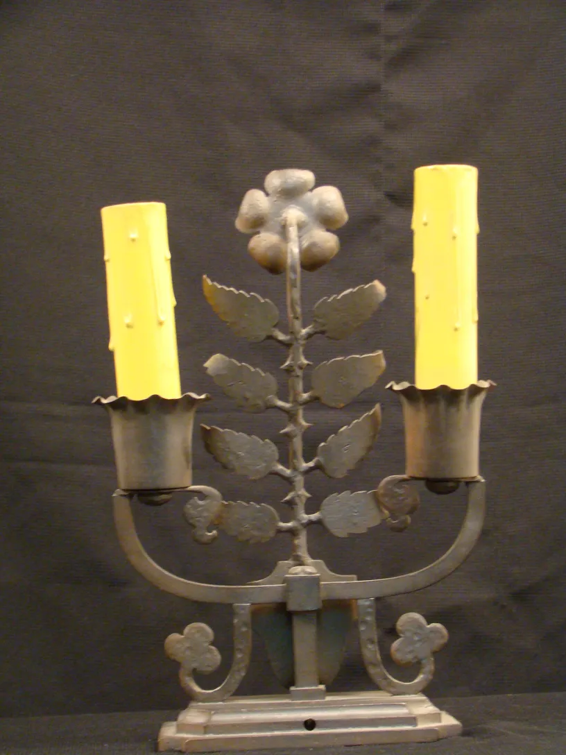 antike tischlampe mit zwei armen und gelben kerzen